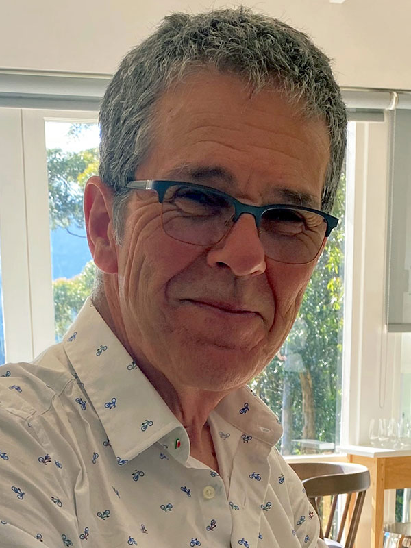 A headshot of Mark Roseman, who wears a white, patterned dress shirt.